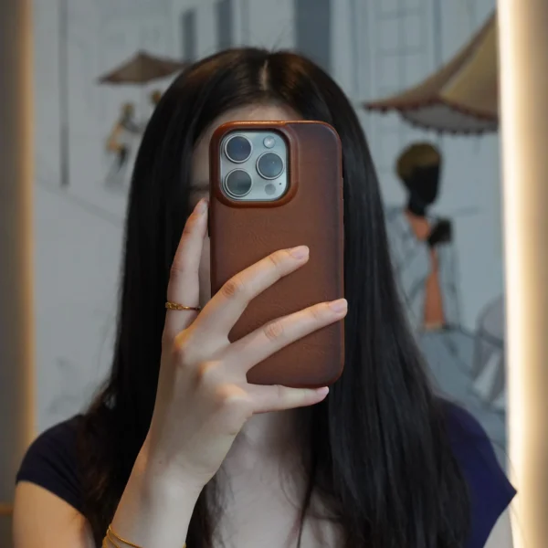 User holding phone up with leather case